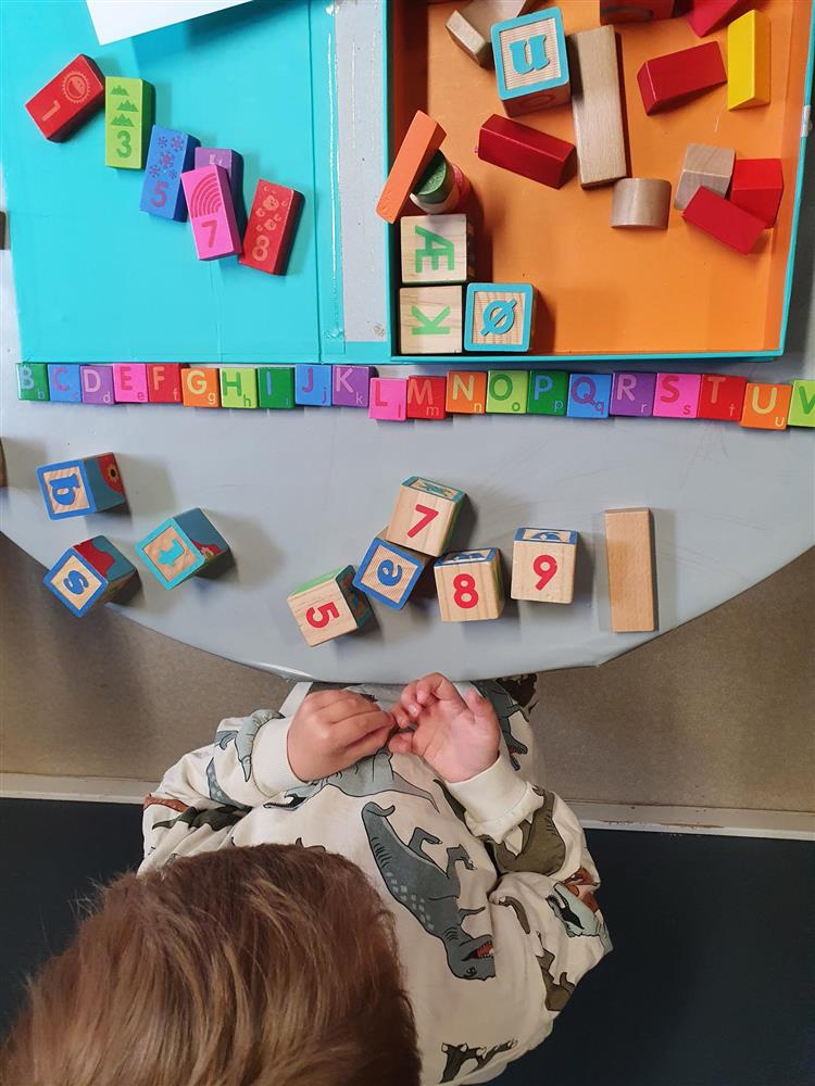 Barn som leker med klosser med bokstaver - Klikk for stort bilde